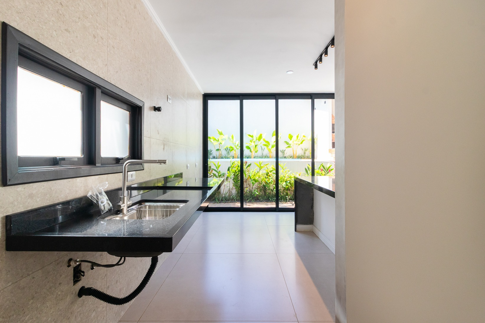 Cozinha com bancadas em granito e vista para o jardim