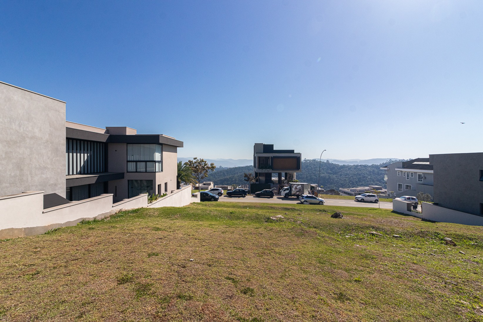Terreno visto a partir da rua, com casas de alto padrão no entorno