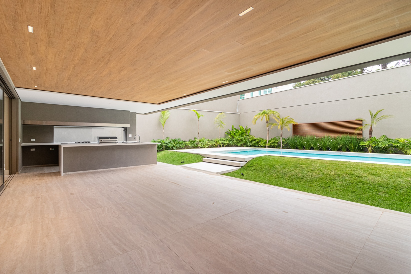 Varanda gourmet com churrasqueira e vista para a piscina