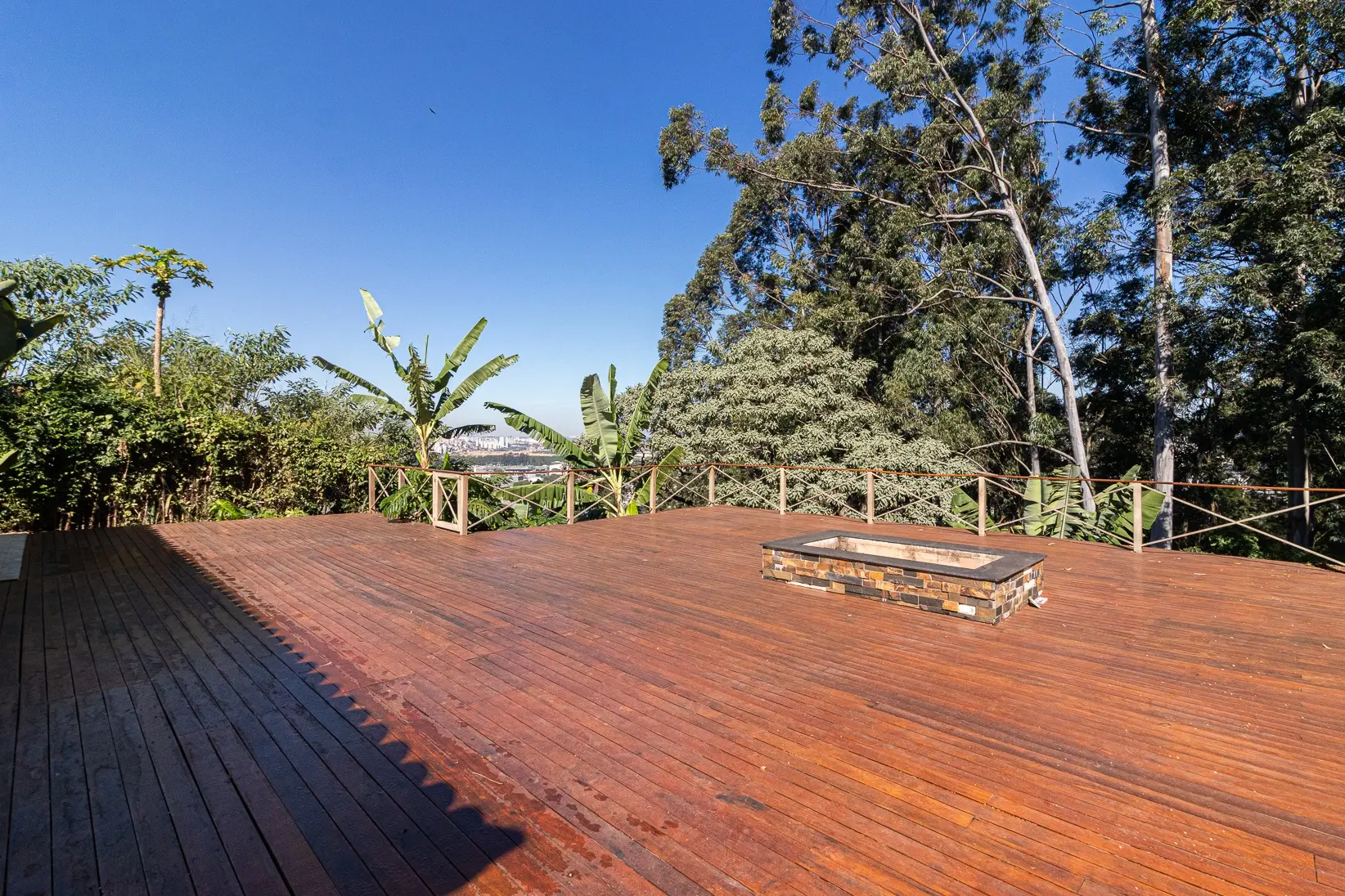 Deck em cumaru com fogo de chão e vista para a reserva