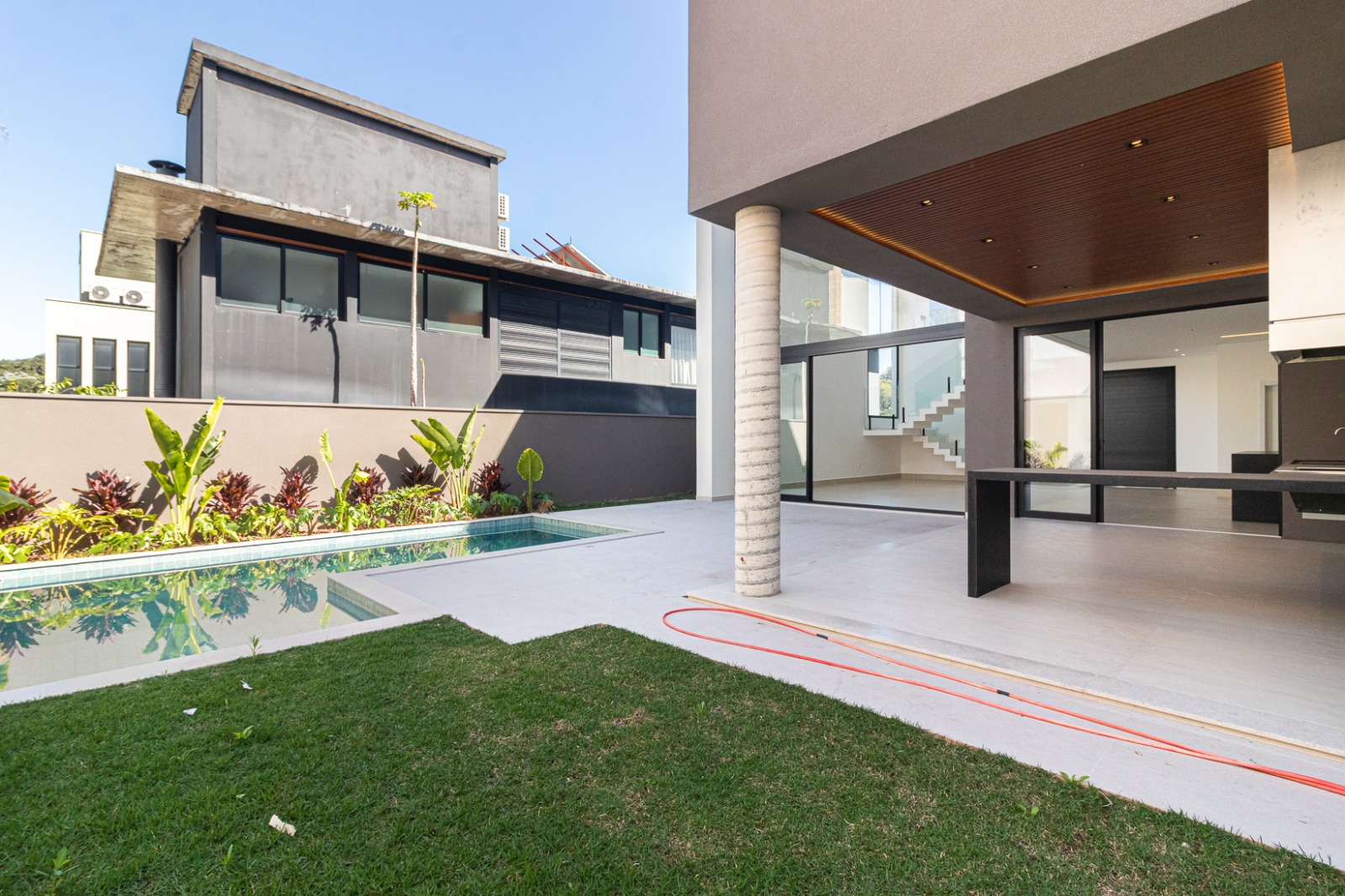 Piscina e jardim com área gourmet ao fundo