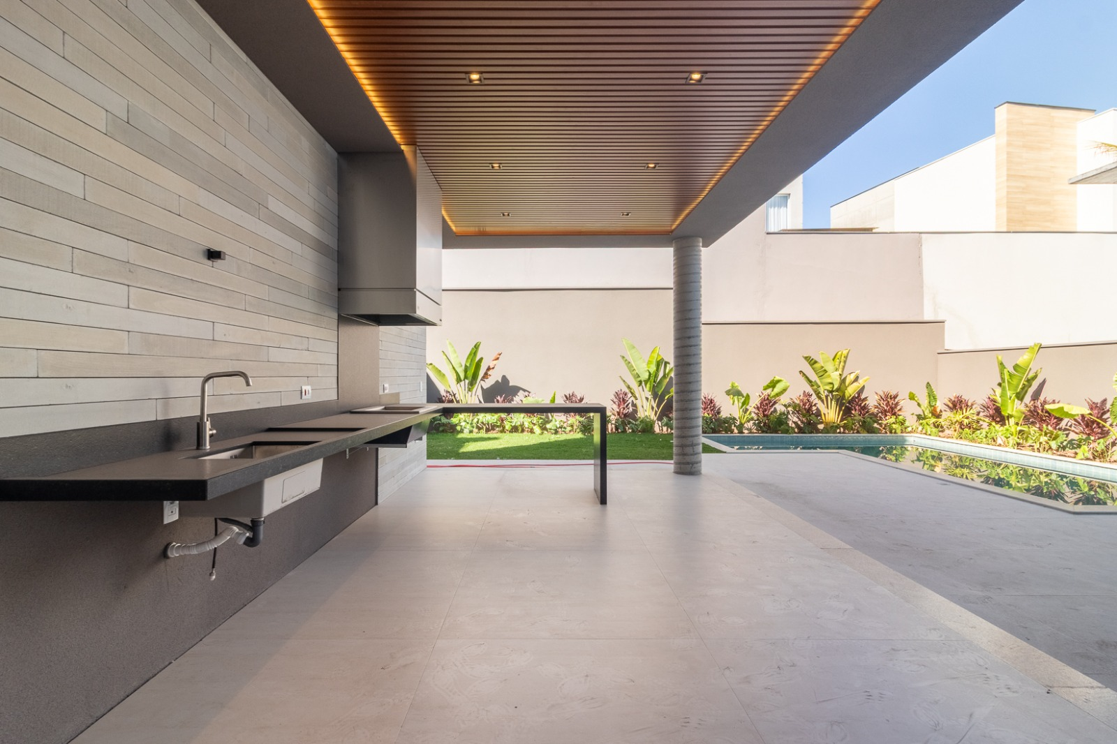 Espaço gourmet coberto com vista para a piscina